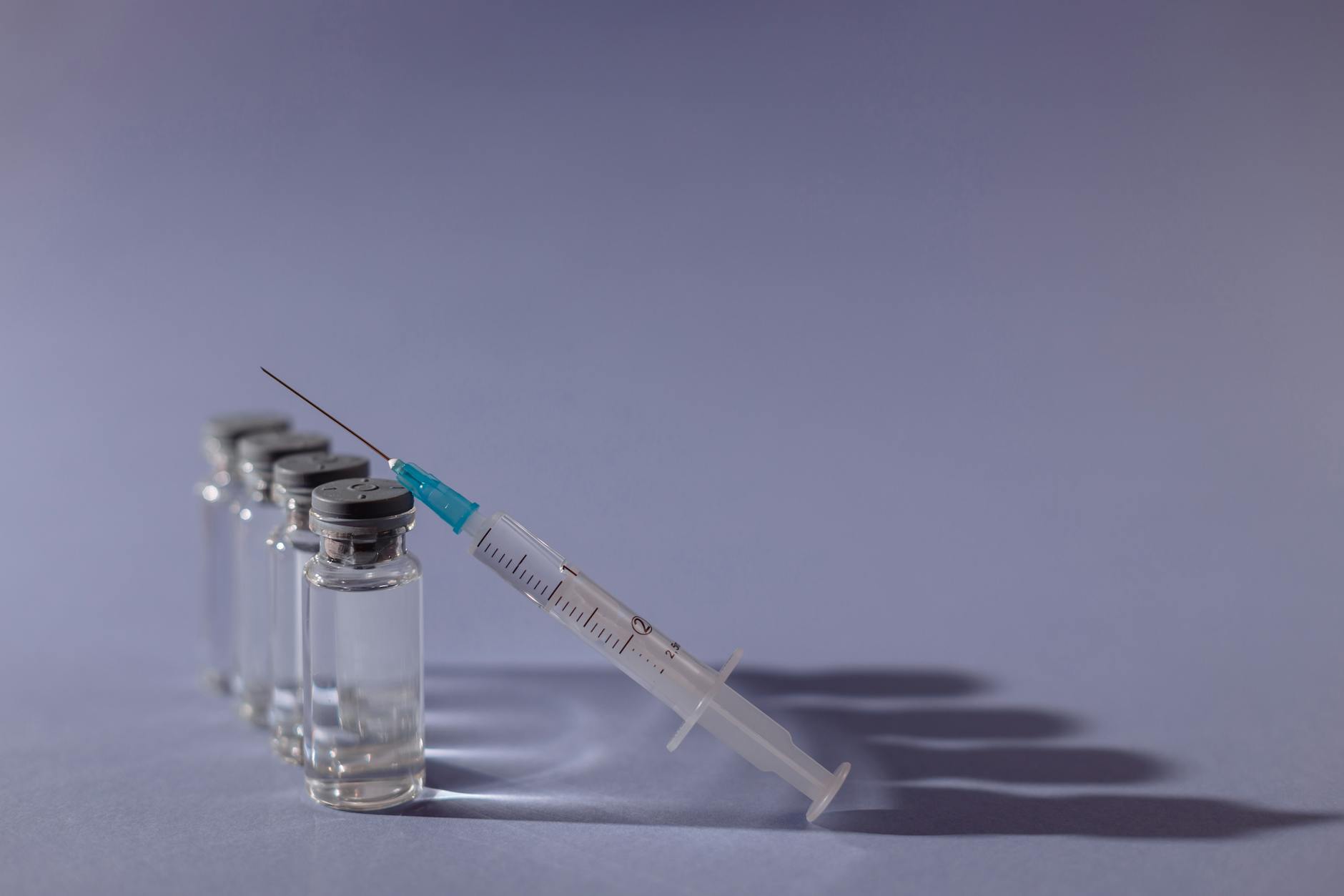Amber medical vial and fine-gauge syringe on a clean surface — BPC-157 and TB-500 peptide clinical trial preparation