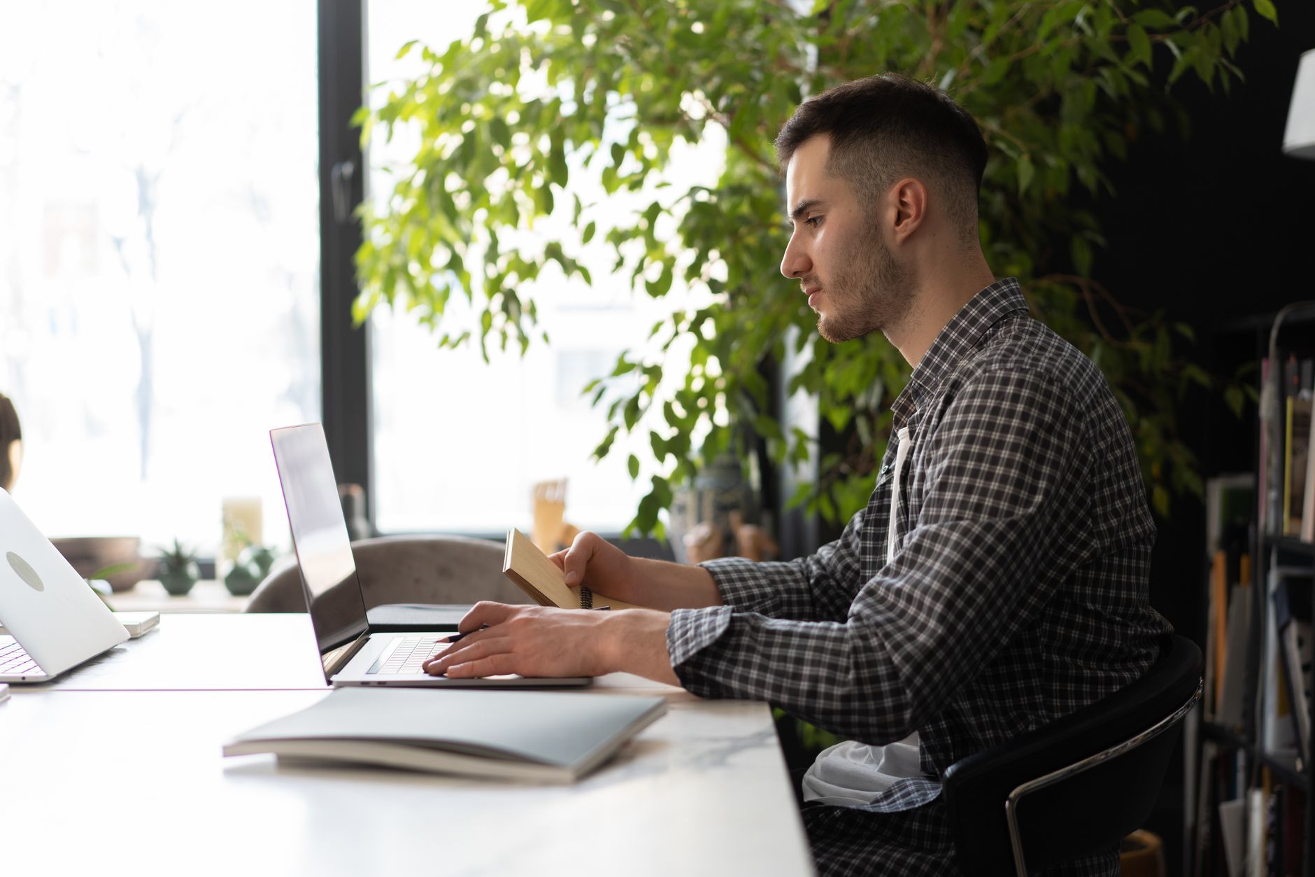 A focused person working at a clean desk with a laptop in bright morning light — citicoline is marketed for sustained attention during this kind of work