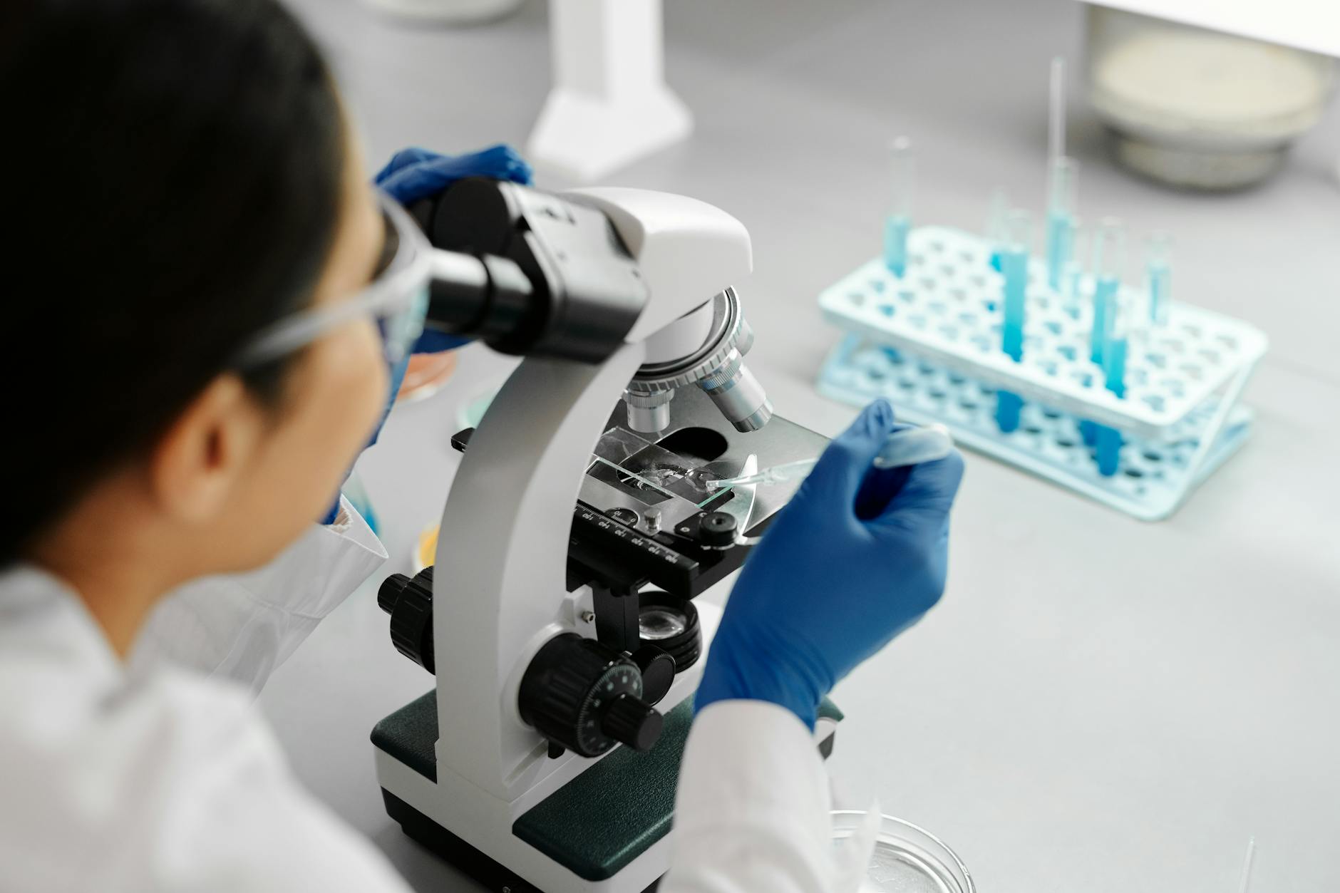 Oncology researcher examining tumour samples under a microscope in a clinical research laboratory — ASCO 2026 GLP-1 cancer metastasis signal in lung breast colorectal and liver cancer