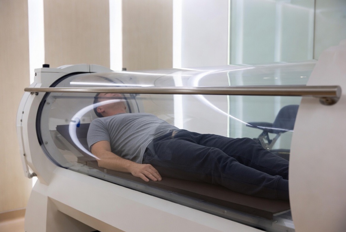 A hyperbaric oxygen chamber &mdash; the recognizable clear cylindrical pressurized chamber is the visual anchor, no identifiable faces