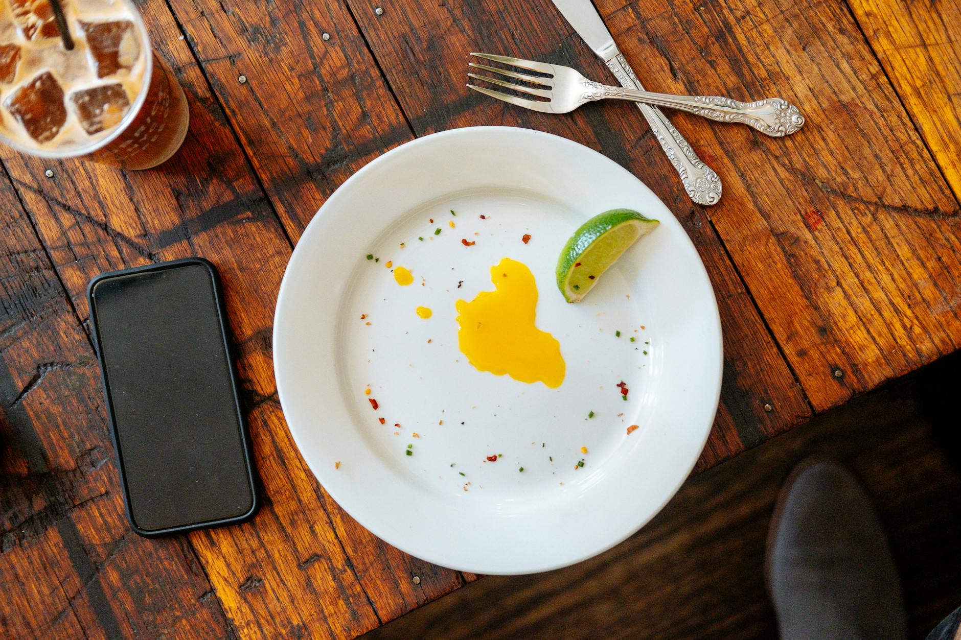 Empty breakfast plate beside a clock — time-restricted eating