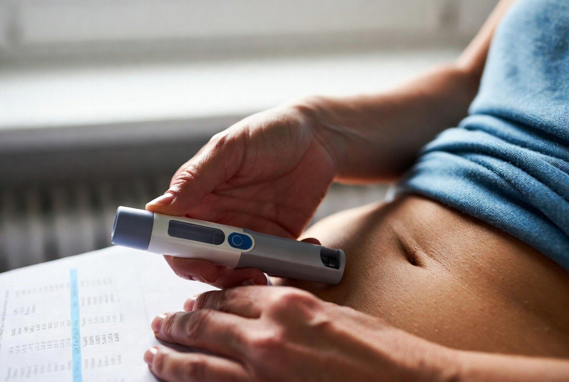 A person self-administering a PCSK9 inhibitor autoinjector pen into the abdomen, with a lipid-panel lab report showing LDL cholesterol numbers on the table beside them