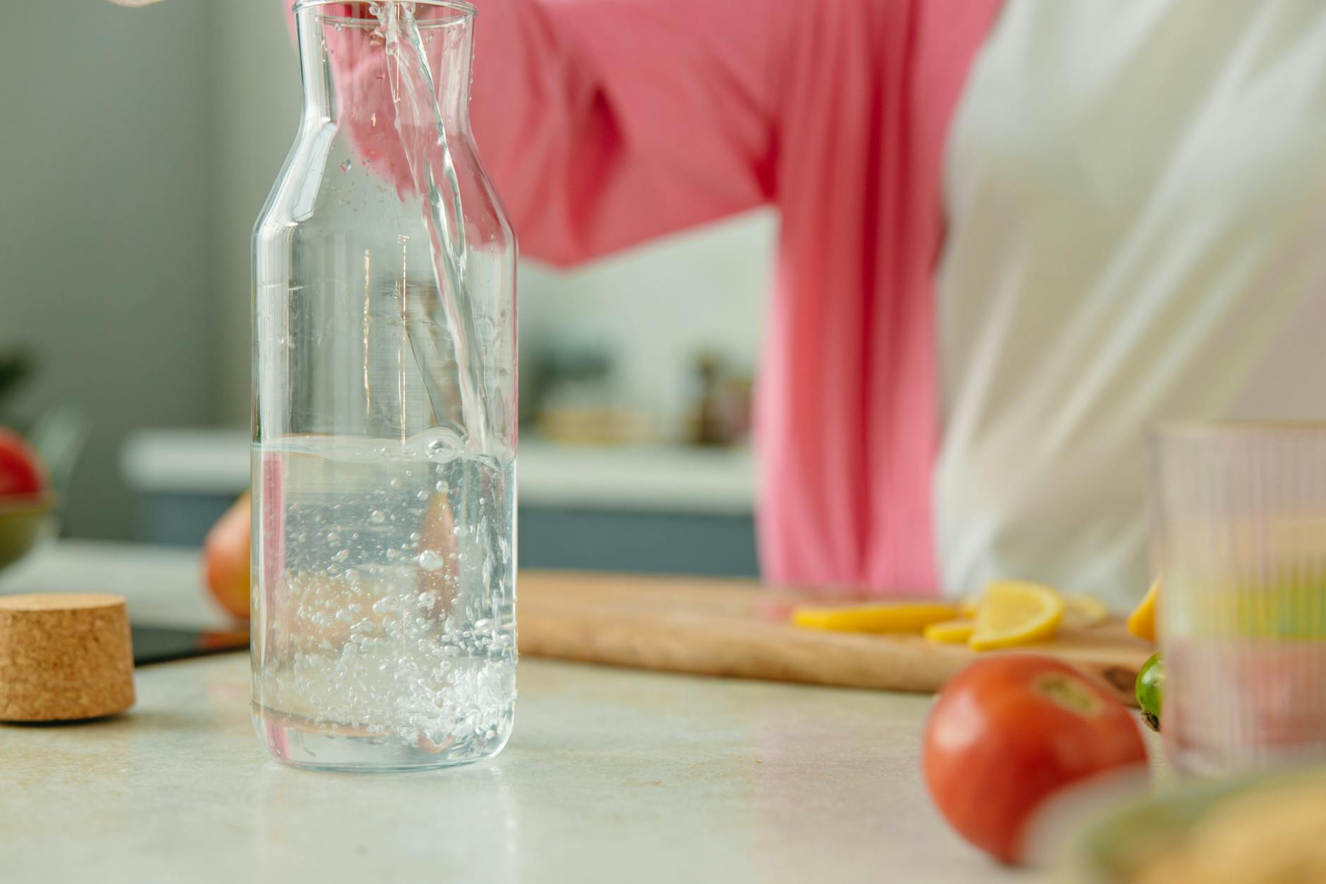 Glass water bottles on a clean kitchen counter — alternatives to plastic containers for reducing endocrine disruptor exposure