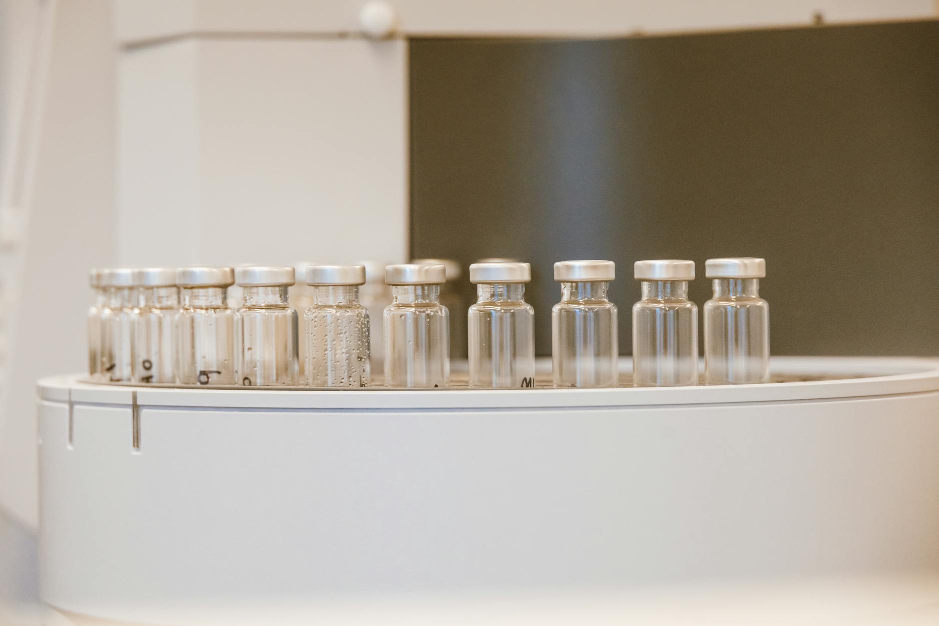 Row of clear research vials in a clinical laboratory analyzer — Selank Phase 2 trial materials