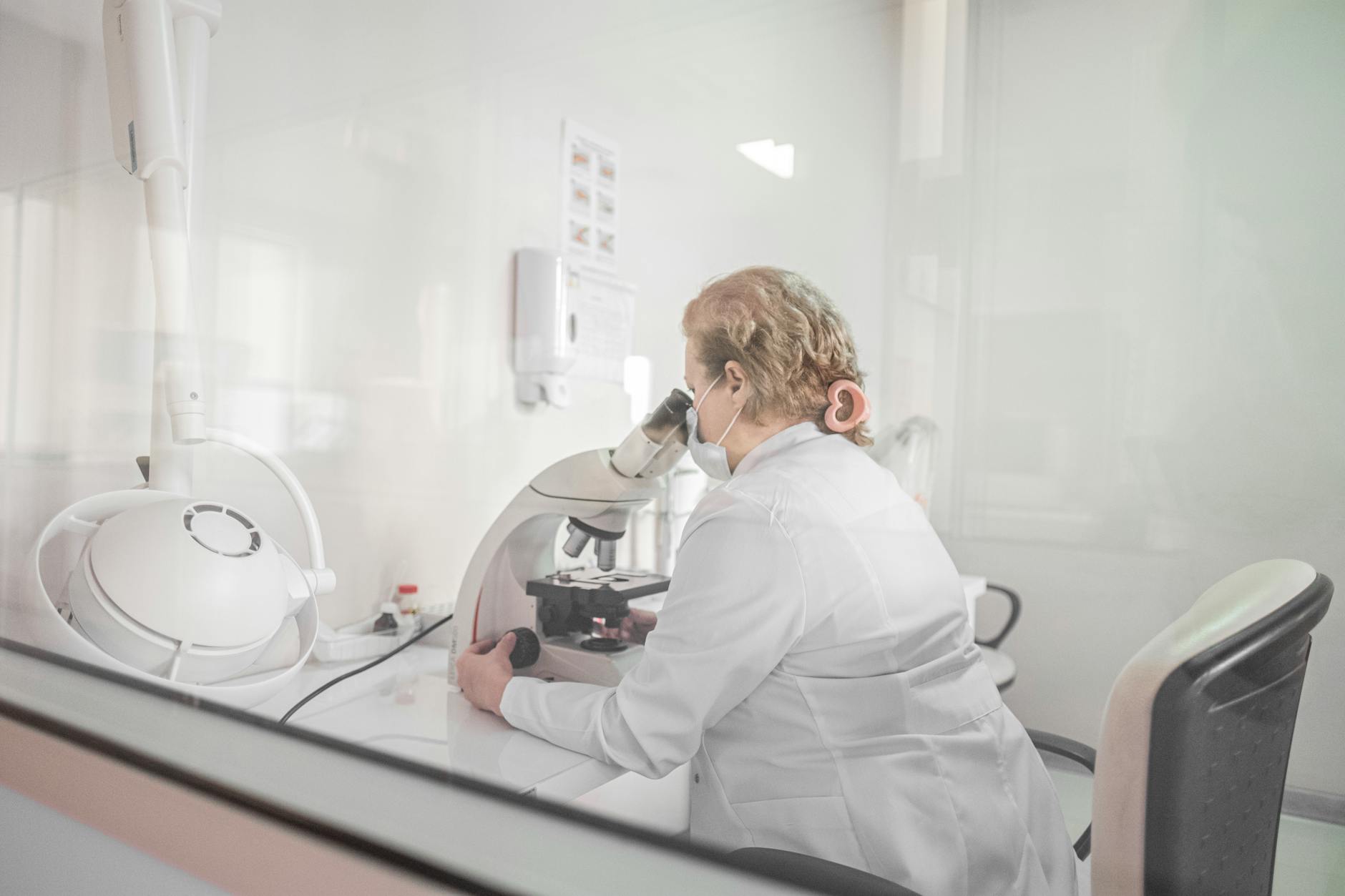 Researcher examining samples at microscope — taurine longevity laboratory study — taurine longevity study