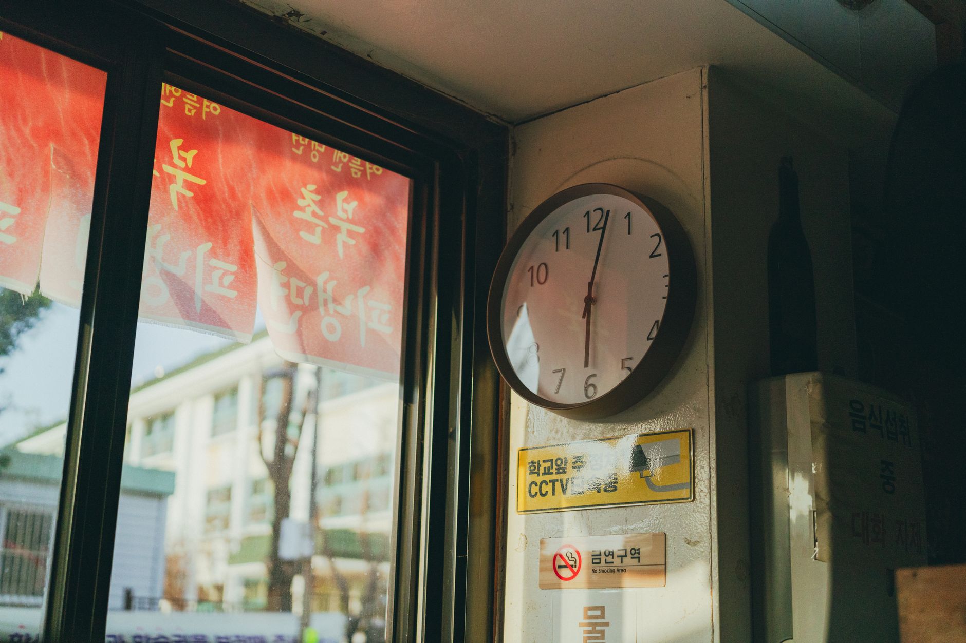 A clock face beside a plate of food on a wooden table, representing the concept of time-restricted eating and fasting windows for brain and metabolic health