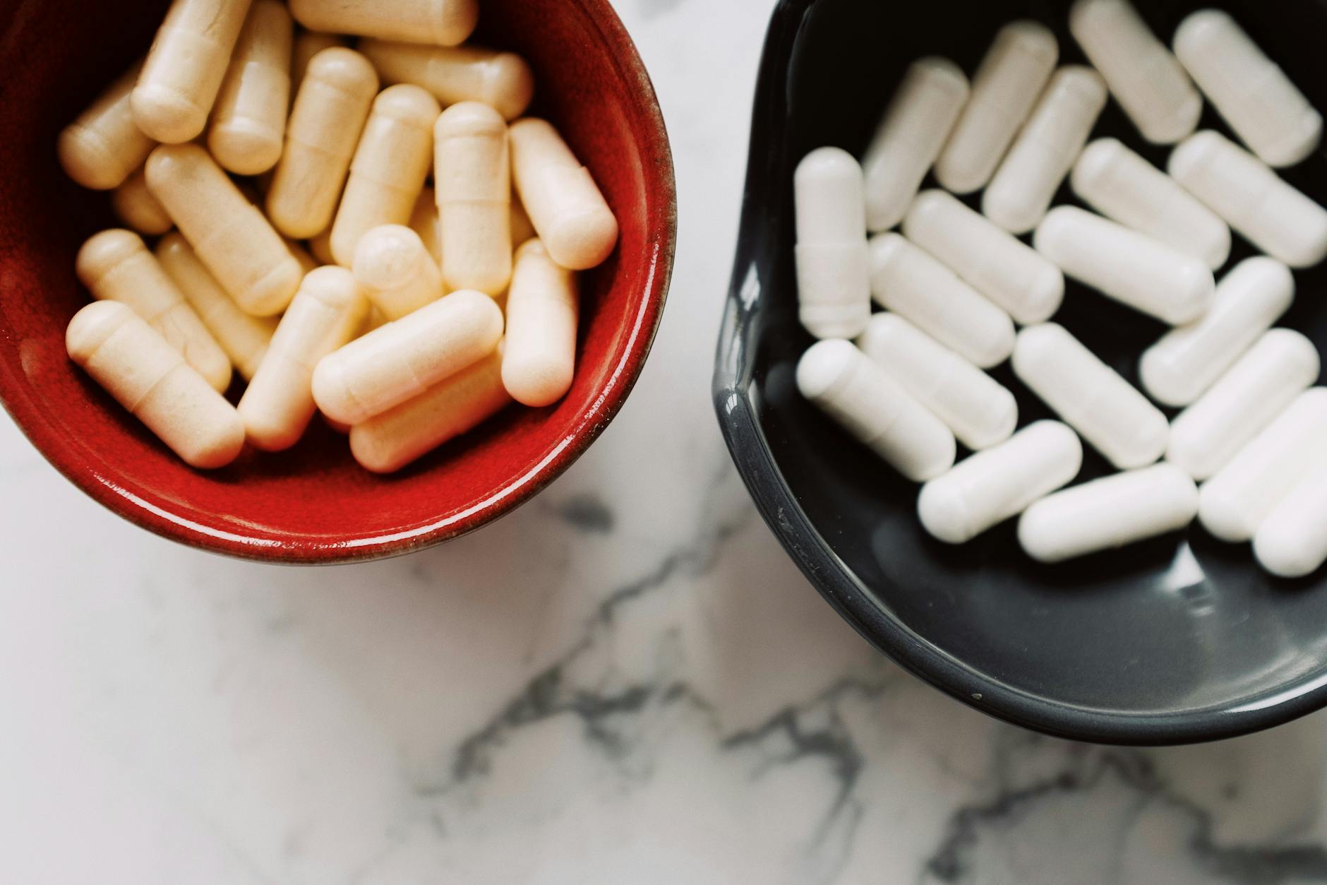Capsules on white surface in directional light — dietary supplements